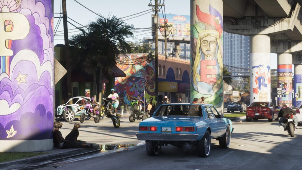 Scène de rue à Vice City avec plusieurs véhicules, dont une berline bleue façon Bravado Buffalo au premier plan